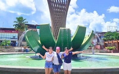 Grupo de turistas posando frente a la fuente de la palmera en la plaza de armas de Tarapoto, durante el city tour
