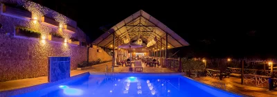 Vista nocturna del restaurante y piscina iluminada en el lodge ecológico Sumaj Lagoon Blue, frente a la Laguna Azul en Tarapoto
