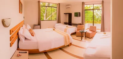 Habitación triple con cama matrimonial y camas adicionales en hotel de Tarapoto, ideal para familias en el paquete Experiencia Sumaj