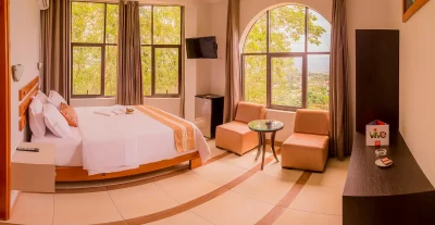 Habitación con cama matrimonial, vista a la naturaleza y servicios completos en hotel de Tarapoto incluido en el paquete Experiencia Sumaj